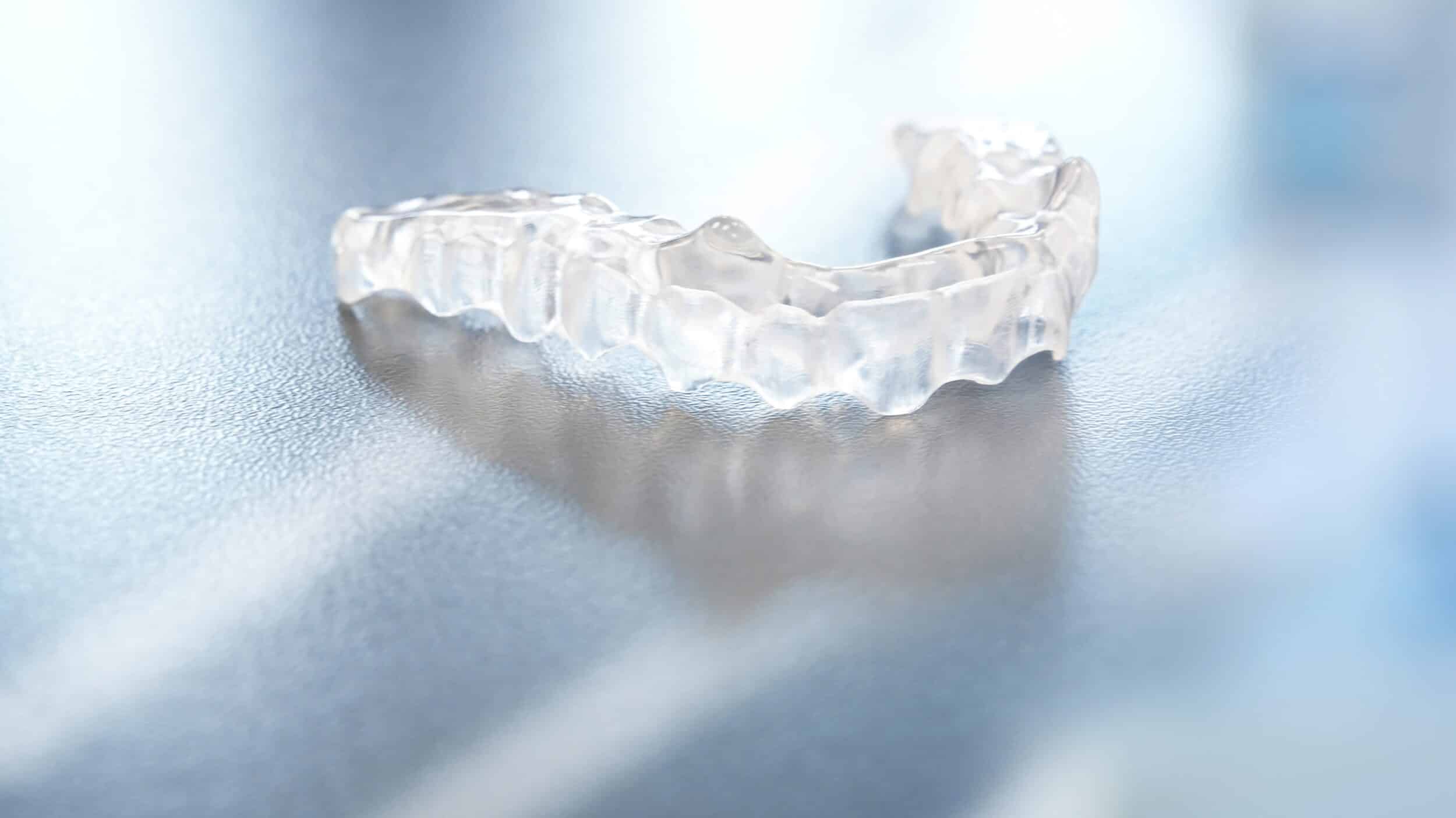 A printed dental splint sits ready for use at the orthodontist’s office, representing modern Invisalign-style aligners for tooth correction and alignment