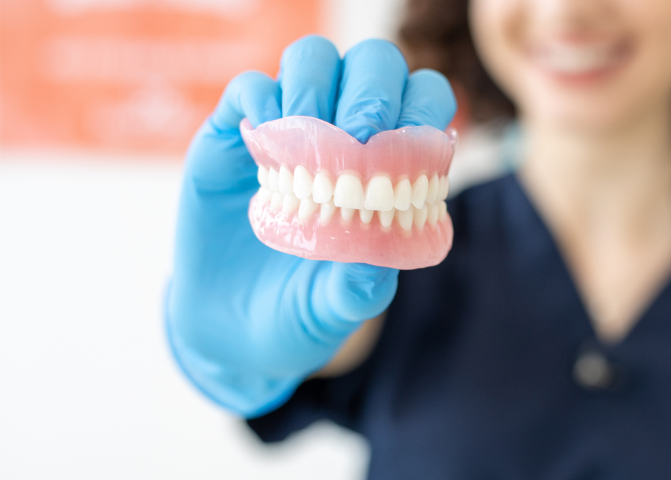 dentist holding a pair of dentures